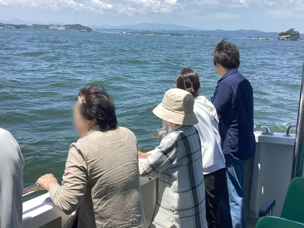 宮城県の塩釜港沖を回遊する海洋散骨ツアーの海と参加者の風景