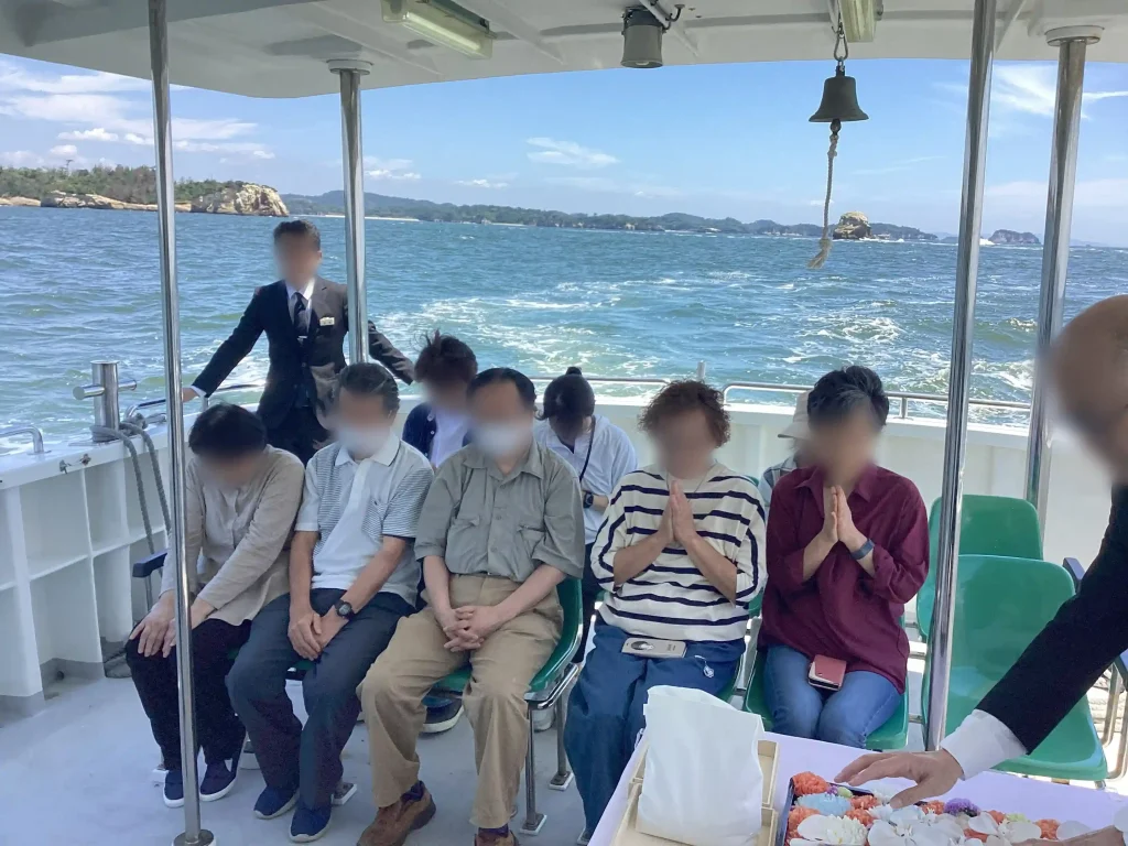 宮城県の塩釜港沖を回遊する海洋散骨ツアーの当日の流れ（黙祷）