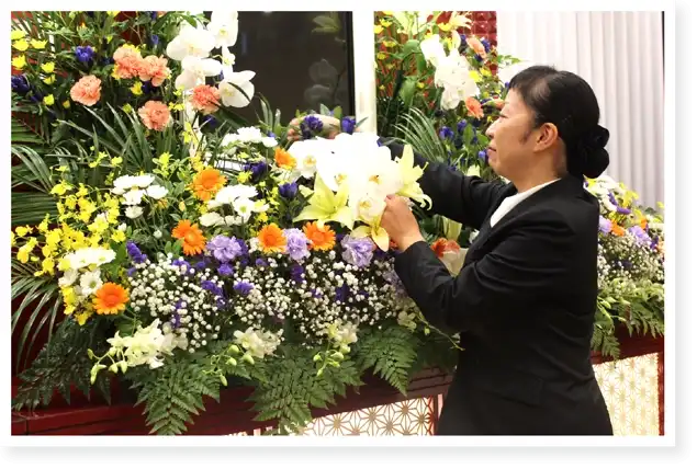 葬儀会場で供花を準備する女性スタッフ